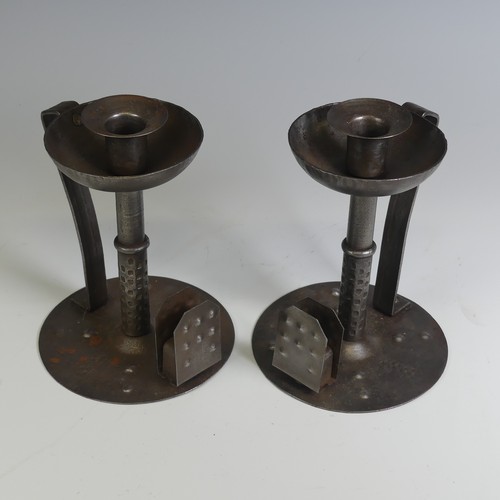 531 - A pair of Arts and Crafts steel Chamber Candlesticks, with angular handles, the flat bases with matc... 