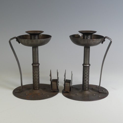 531 - A pair of Arts and Crafts steel Chamber Candlesticks, with angular handles, the flat bases with matc... 