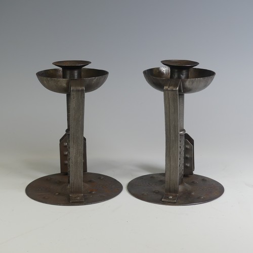 531 - A pair of Arts and Crafts steel Chamber Candlesticks, with angular handles, the flat bases with matc... 