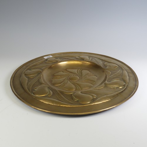 560 - An Arts and Crafts brass Charger, decorated with Art Nouveau inspired stylised foliage, W 46 cm.... 