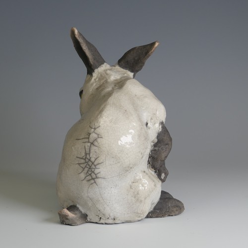 366 - Keza Rudge (British 20th century) a studio pottery Raku Rabbit, modelled in seated position with tur... 