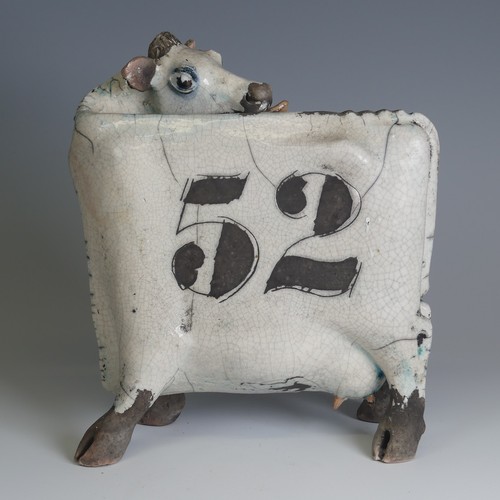 367 - Lawson E. Rudge (b. 1936), a raku fired pottery sculpture of a licking Flat Cow, spot pattern and nu... 