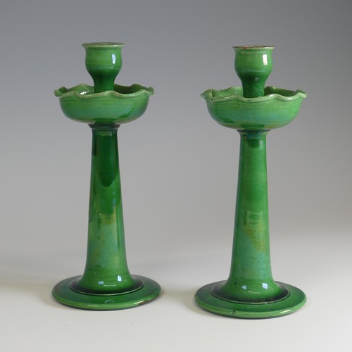 371 - A pair of C.H. Brannam for Liberty & Co Candlesticks, with fluted drip pans, decorated in a gree... 