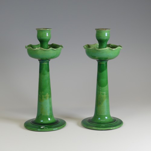 371 - A pair of C.H. Brannam for Liberty & Co Candlesticks, with fluted drip pans, decorated in a gree... 