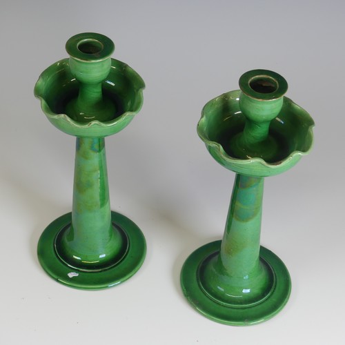 371 - A pair of C.H. Brannam for Liberty & Co Candlesticks, with fluted drip pans, decorated in a gree... 