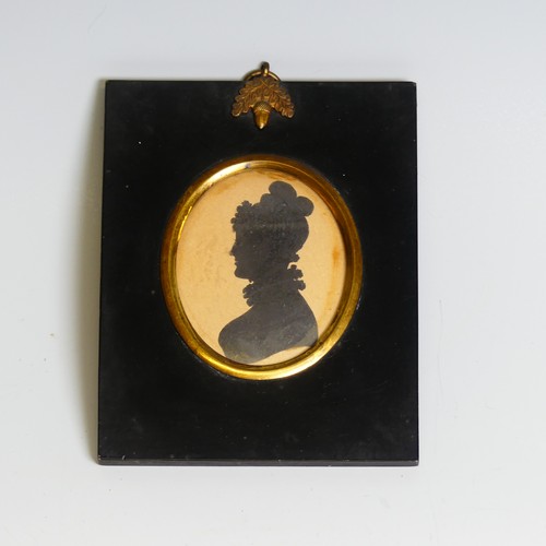 390 - An oval silhouette of a young man, 19th century, heightened with gilt, mounted in an embossed metal ... 