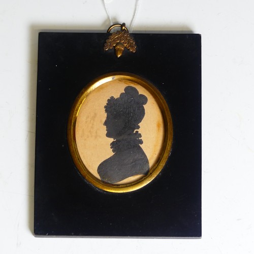 390 - An oval silhouette of a young man, 19th century, heightened with gilt, mounted in an embossed metal ... 