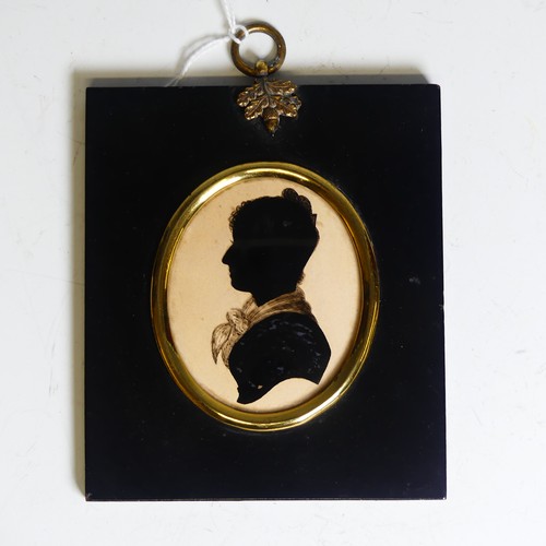 390 - An oval silhouette of a young man, 19th century, heightened with gilt, mounted in an embossed metal ... 