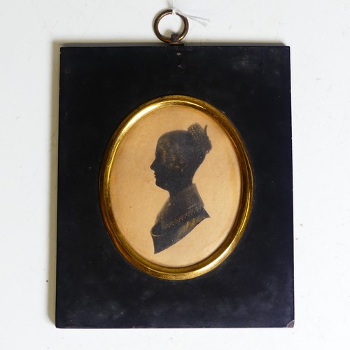 390 - An oval silhouette of a young man, 19th century, heightened with gilt, mounted in an embossed metal ... 