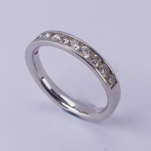  A diamond half hoop Eternity Ring, channel set with eleven brilliant cut stones, total diamond weigh... 