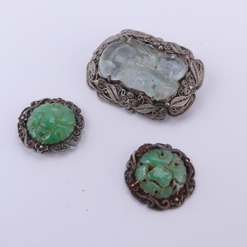 243 - A Chinese carved jade Brooch, in a filigree foliate silver mount, 4cm long, together with two carved... 