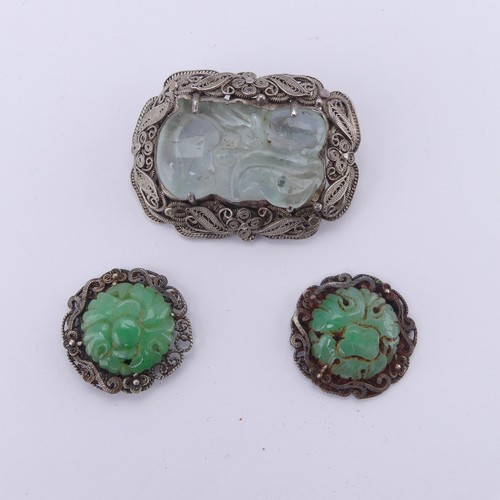 243 - A Chinese carved jade Brooch, in a filigree foliate silver mount, 4cm long, together with two carved... 