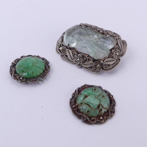 243 - A Chinese carved jade Brooch, in a filigree foliate silver mount, 4cm long, together with two carved... 