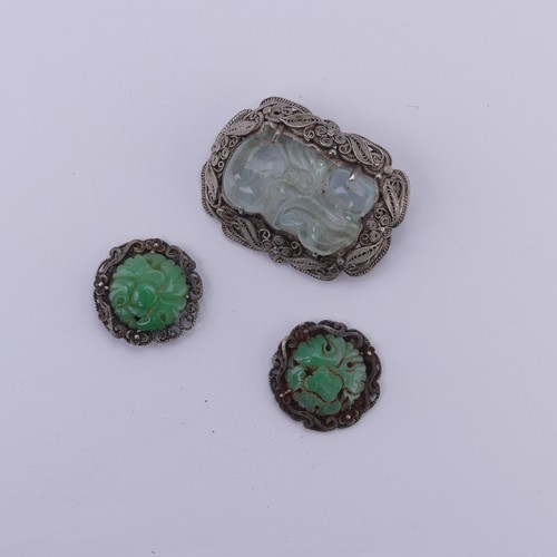 243 - A Chinese carved jade Brooch, in a filigree foliate silver mount, 4cm long, together with two carved... 