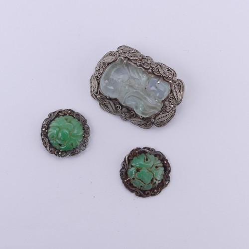 243 - A Chinese carved jade Brooch, in a filigree foliate silver mount, 4cm long, together with two carved... 