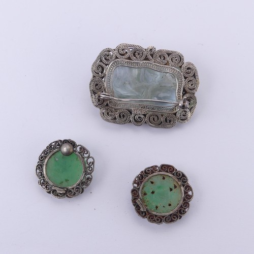 243 - A Chinese carved jade Brooch, in a filigree foliate silver mount, 4cm long, together with two carved... 