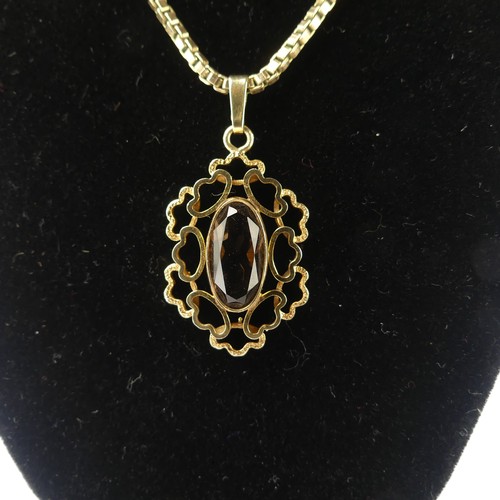 183 - An abstract 9ct yellow gold Pendant, the centre set with an oval facetted smoky quartz, 3cm long, on... 