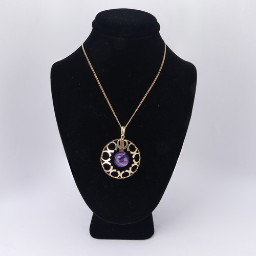 186 - A modernist amethyst 9ct gold Pendant, of open circular form with central cabochon amethyst, hallmar... 