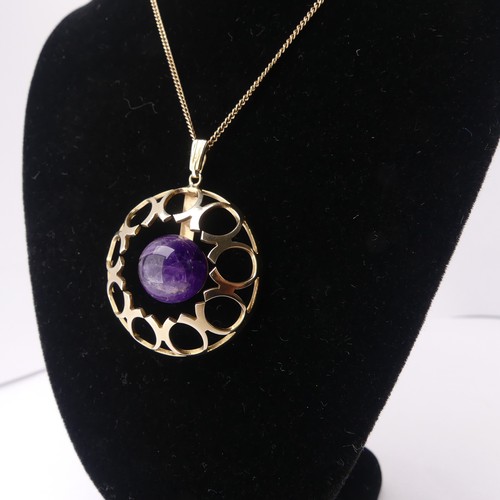 186 - A modernist amethyst 9ct gold Pendant, of open circular form with central cabochon amethyst, hallmar... 