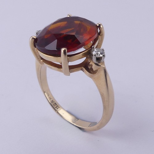 140 - A fire opal and diamond Ring, the central oval facetted stone approx. 12mm long, four claw set in 14... 