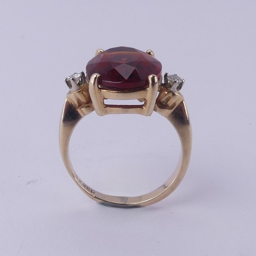 140 - A fire opal and diamond Ring, the central oval facetted stone approx. 12mm long, four claw set in 14... 