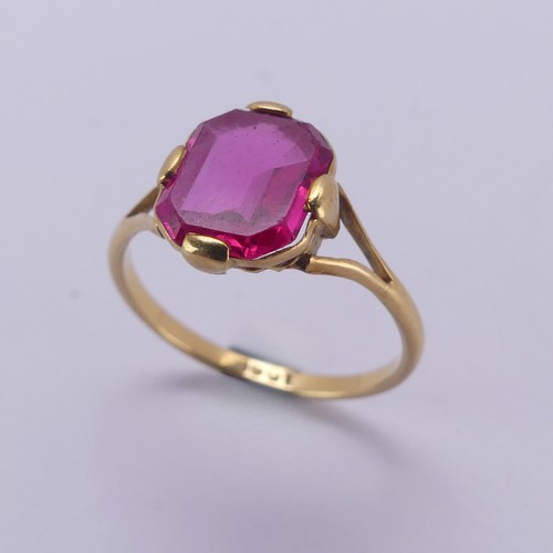 150 - A single stone pink sapphire Ring, the rectangular stone with canted corners, in four claw 18ct gold... 