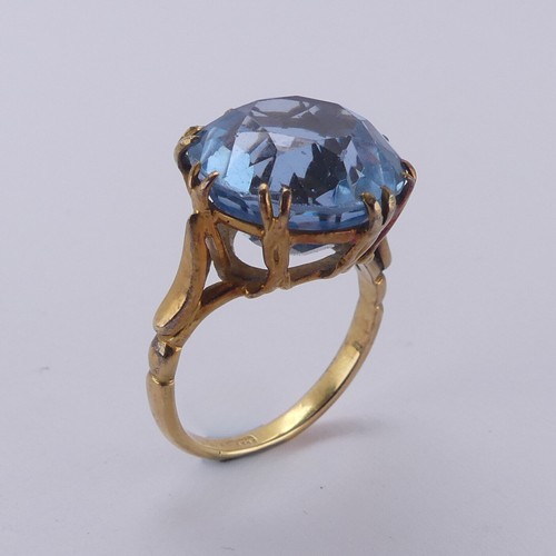 160 - A circular facetted blue stone Ring, approx. 14mm diameter, claw set in an 18ct yellow gold cagework... 