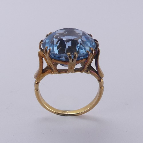 160 - A circular facetted blue stone Ring, approx. 14mm diameter, claw set in an 18ct yellow gold cagework... 