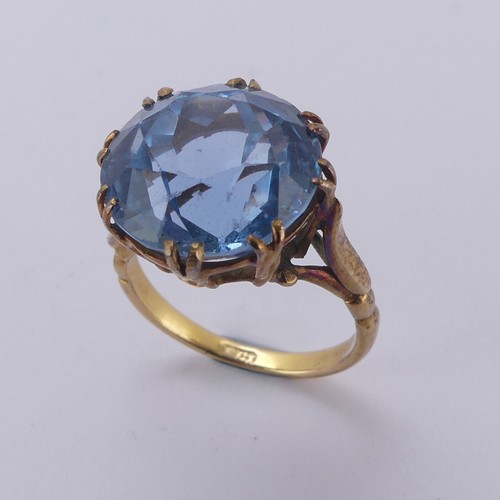 160 - A circular facetted blue stone Ring, approx. 14mm diameter, claw set in an 18ct yellow gold cagework... 