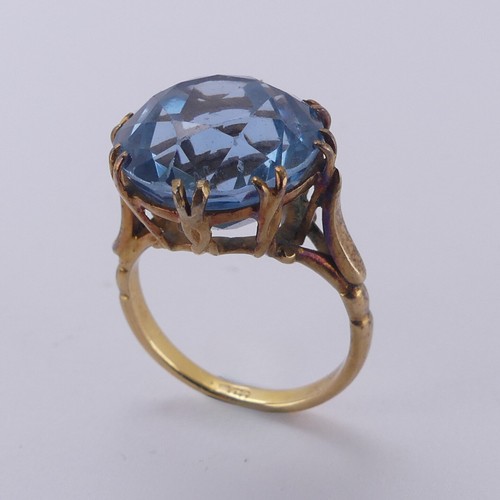 160 - A circular facetted blue stone Ring, approx. 14mm diameter, claw set in an 18ct yellow gold cagework... 