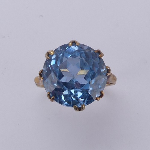 160 - A circular facetted blue stone Ring, approx. 14mm diameter, claw set in an 18ct yellow gold cagework... 