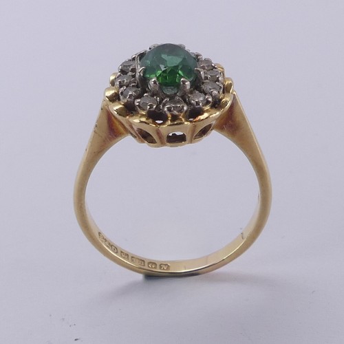 161 - A demantoid garnet and diamond cluster Ring, the oval facetted garnet, approx. 6.8mm long, surrounde... 