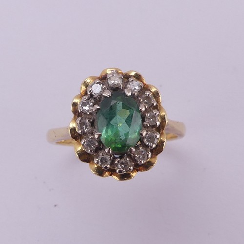 161 - A demantoid garnet and diamond cluster Ring, the oval facetted garnet, approx. 6.8mm long, surrounde... 