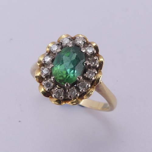 161 - A demantoid garnet and diamond cluster Ring, the oval facetted garnet, approx. 6.8mm long, surrounde... 