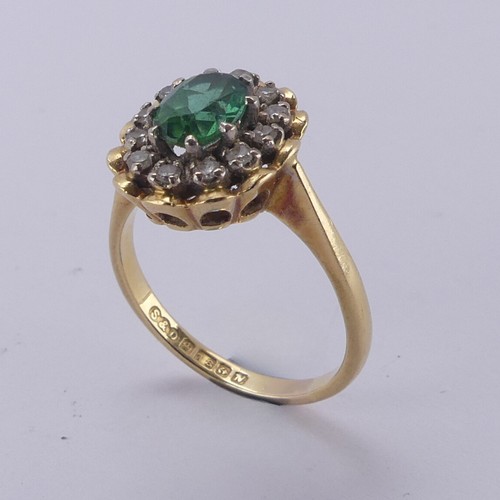 161 - A demantoid garnet and diamond cluster Ring, the oval facetted garnet, approx. 6.8mm long, surrounde... 