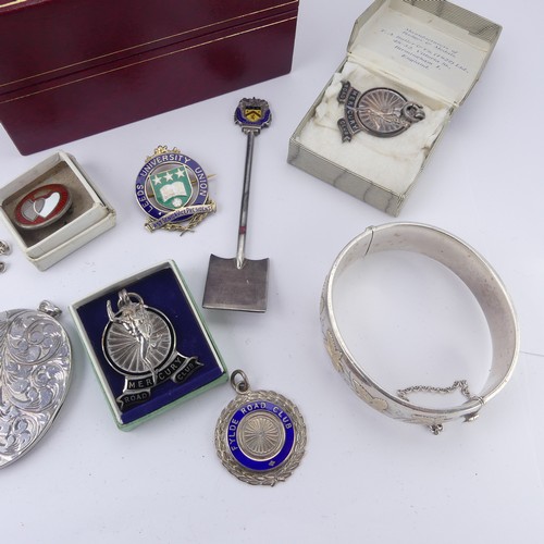 270 - A silver hinged Bangle, with gilt foliate decoration, together with a quantity of silver prize fobs ... 