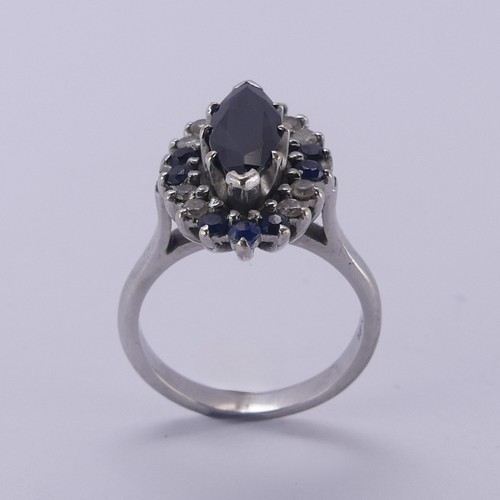 176 - A Sapphire and diamond cluster Dress Ring, the navette shaped facetted central sapphire approx. 12.9... 