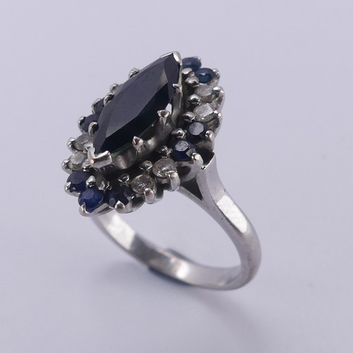 176 - A Sapphire and diamond cluster Dress Ring, the navette shaped facetted central sapphire approx. 12.9... 