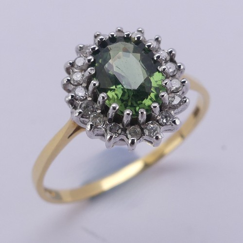 177 - A green sapphire and diamond cluster Ring, the oval facetted central stone approx. 8mm long, surroun... 