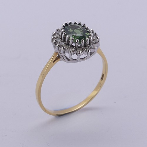 177 - A green sapphire and diamond cluster Ring, the oval facetted central stone approx. 8mm long, surroun... 