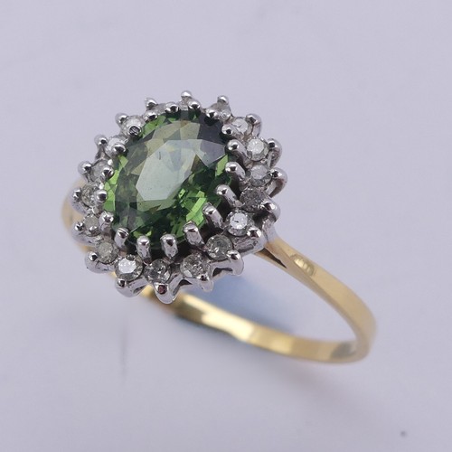 177 - A green sapphire and diamond cluster Ring, the oval facetted central stone approx. 8mm long, surroun... 