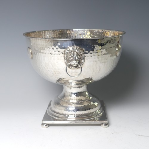 55 - A silver plated Punch Bowl, with hammered decoration and lion mask ring handles, raised on square ba... 