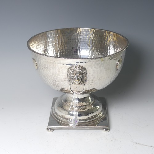 55 - A silver plated Punch Bowl, with hammered decoration and lion mask ring handles, raised on square ba... 