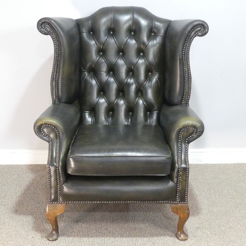 672 - A 20th century green Chesterfield style wingback Armchair, W 92 cm x H 108 cm x D 85 cm.... 