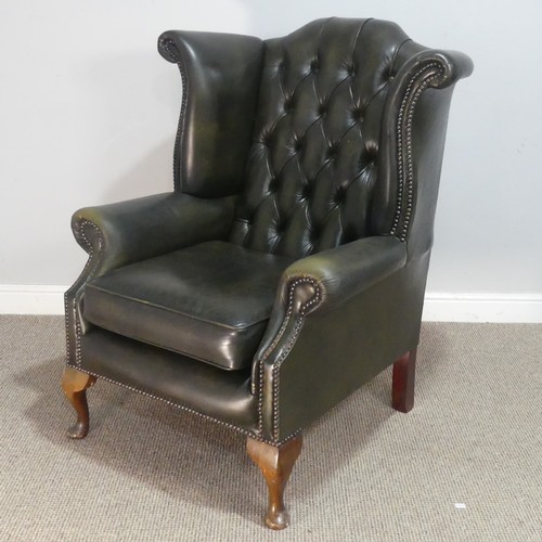 672 - A 20th century green Chesterfield style wingback Armchair, W 92 cm x H 108 cm x D 85 cm.... 