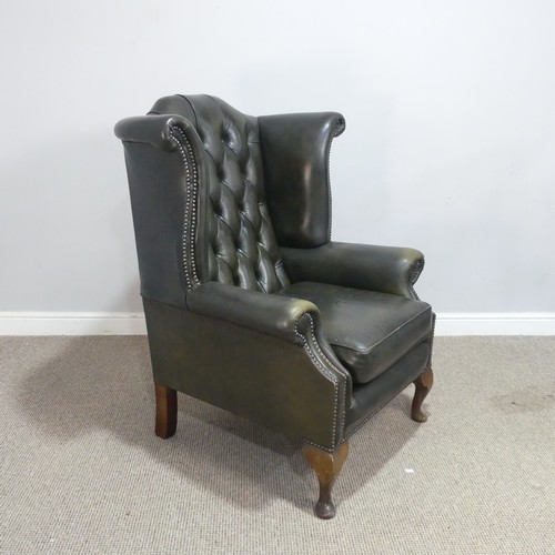 672 - A 20th century green Chesterfield style wingback Armchair, W 92 cm x H 108 cm x D 85 cm.... 