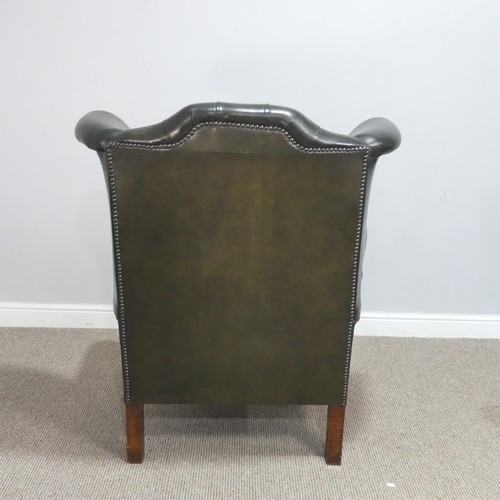 672 - A 20th century green Chesterfield style wingback Armchair, W 92 cm x H 108 cm x D 85 cm.... 