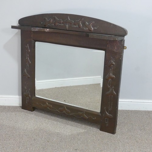 In the manner of Liberty & Co a large Arts and Crafts copper framed overmantel Mirror, possibly by J & F Pool of Hayle, with an arched top and open shelf, above beveled mirror and hammered frame, the framed decorated with stylised foliage, W 105 cm x H 96 cm x D 16 cm.