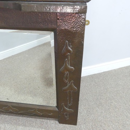 516 - In the manner of Liberty & Co a large Arts and Crafts copper framed overmantel Mirror, possibly ... 