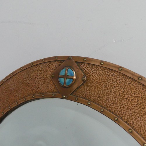 532 - In the manner of Liberty & Co an Arts and Crafts copper Mirror, the circular hammered copper fra... 